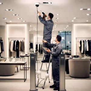 Deux techniciens installant un kit de vidéoprotection, eas système antivol